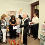 Archbishop Aquila blesses the new Gabriel House in Centro San Juan Diego while Larry Miller, Viviana Martinez,Shamika Ward, Kallyn Webster, Alfonso Lara and Mimi Eckstein look on during the opening ceremony for the 5th Gabriel House in Centro San Juan Diego in Denver on May 29th.