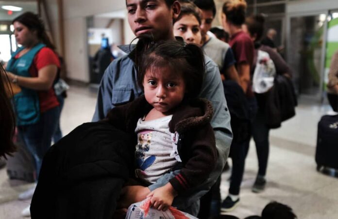 MCALLEN, TX - JUNE 23: A Guatemalan father and his daughter arrives with dozens of other women, men and their children at a bus station following release from Customs and Border Protection on June 23, 2018 in McAllen, Texas. Once families and individuals are released and given a court hearing date they are brought to the Catholic Charities Humanitarian Respite Center to rest, clean up, enjoy a meal and to get guidance to their next destination. Before President Donald Trump signed an executive order Wednesday that halts the practice of separating families who are seeking asylum, over 2,300 immigrant children had been separated from their parents in the zero-tolerance policy for border crossers (Photo by Spencer Platt/Getty Images)